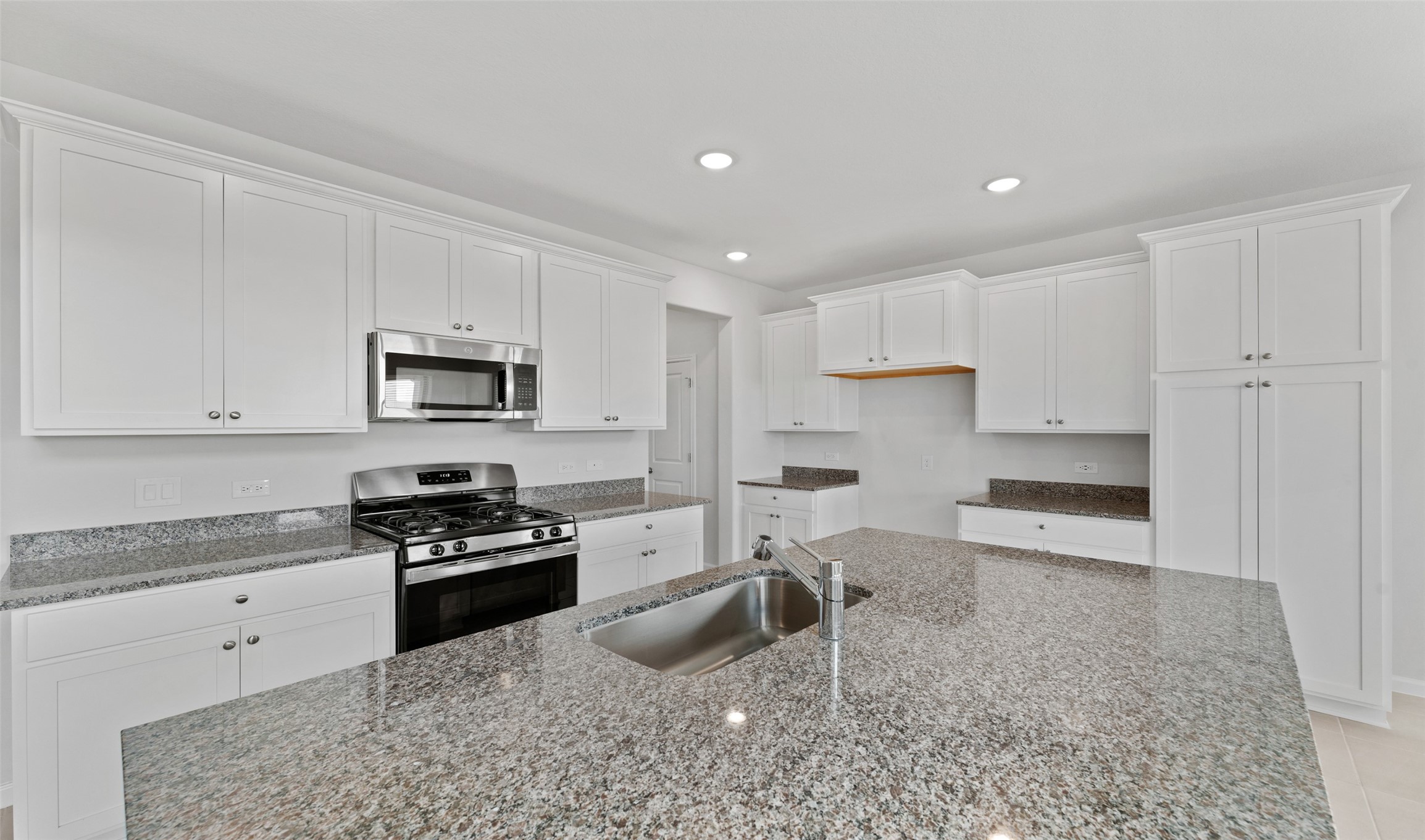 29306 Suncreek Rnch Court Waller, TX 77484 - Photo 5 of 27 a kitchen with granite countertop a sink white cabinets and stainless steel appliances