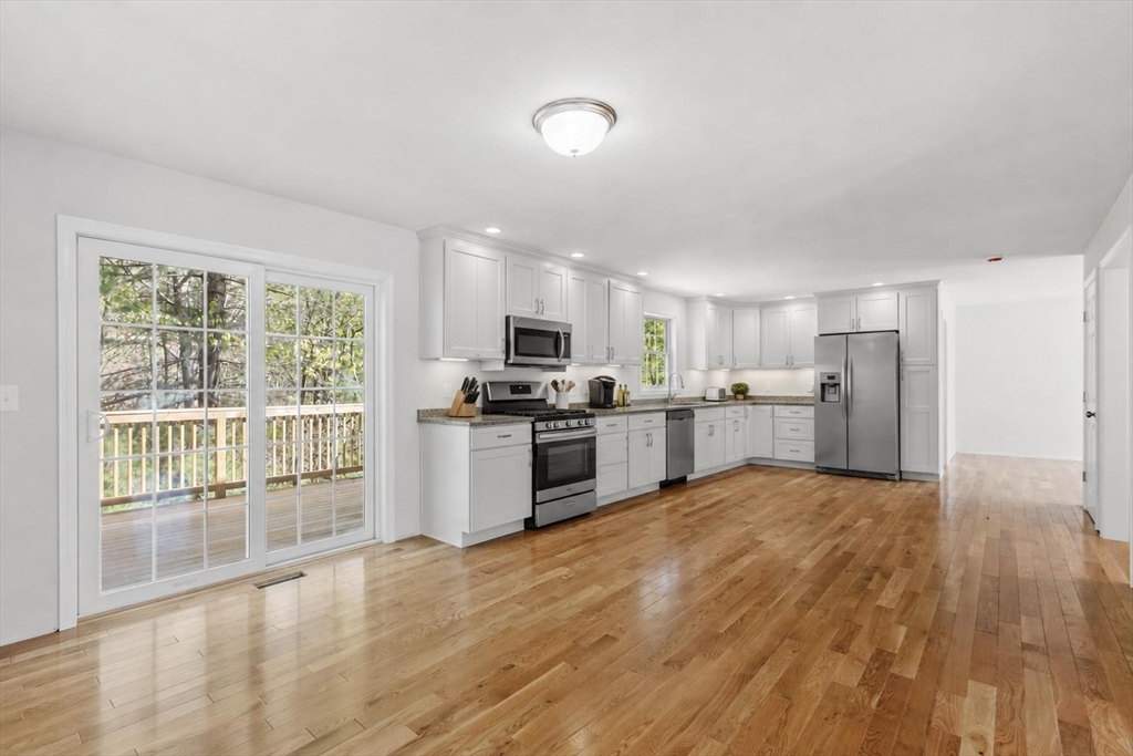 22 Benoit Avenue Pelham, NH 03076 - Photo 8 of 42 a large white kitchen with wooden floor and stainless steel appliances