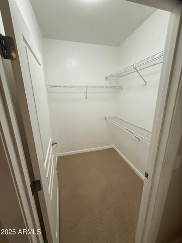 a view of walk in closet with empty racks