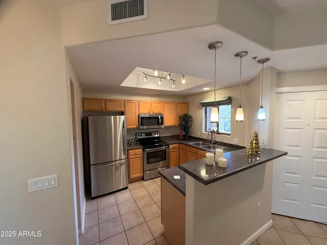a kitchen with granite countertop a refrigerator and a sink