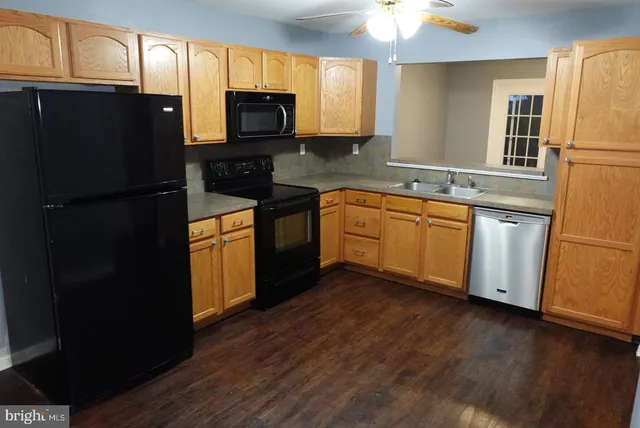 a kitchen with stainless steel appliances granite countertop a refrigerator stove a sink and dishwasher with wooden floor