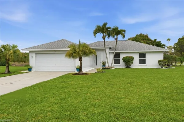 a front view of house with yard and outdoor seating