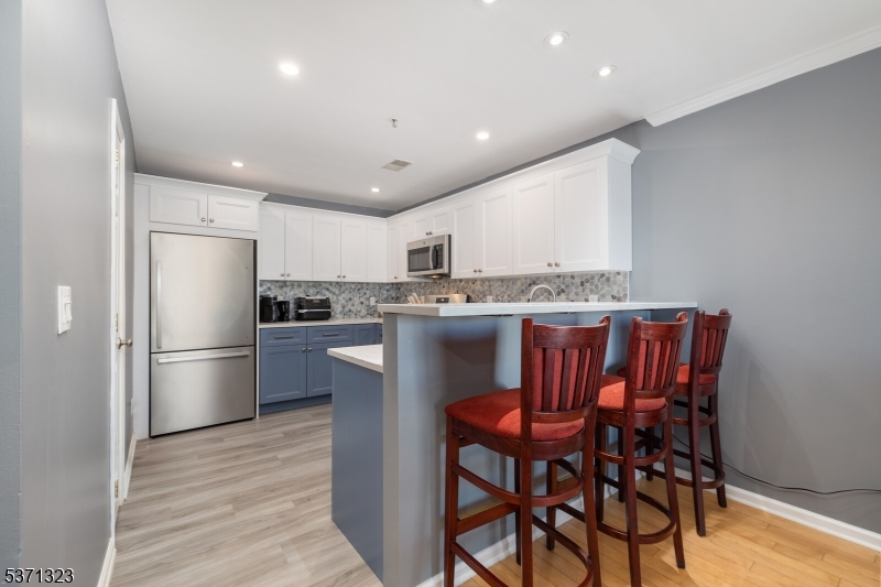 56 King George Road Green Brook, NJ 08812 - Photo 9 of 20 a kitchen with stainless steel appliances granite countertop a dining table chairs refrigerator and cabinets