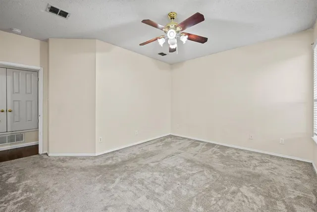 an empty room with a chandelier fan