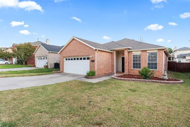 a view of a house with a big yard and large tree and plants