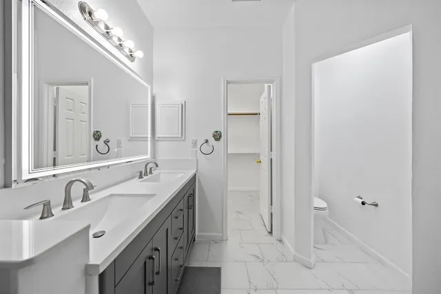 a spacious bathroom with a double vanity sink a mirror and a bathtub