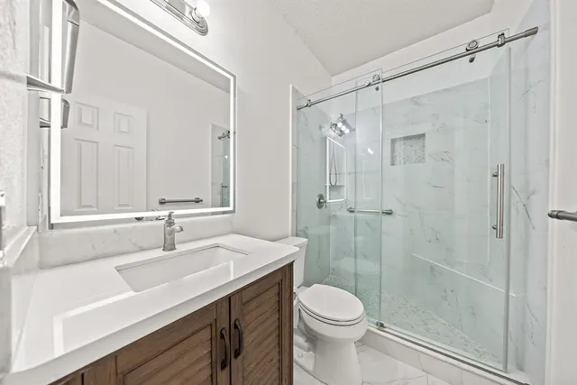 a bathroom with a sink a toilet and shower