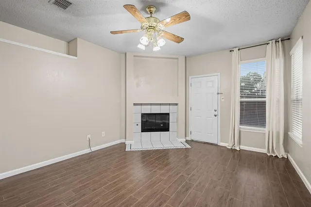 a view of an empty room with a fireplace and a window