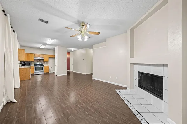 a view of a livingroom with wooden floor and a kitchen