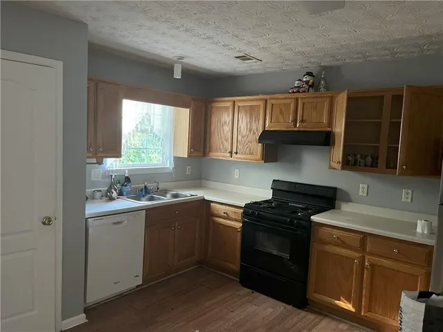 a kitchen with a sink stove top oven and cabinets