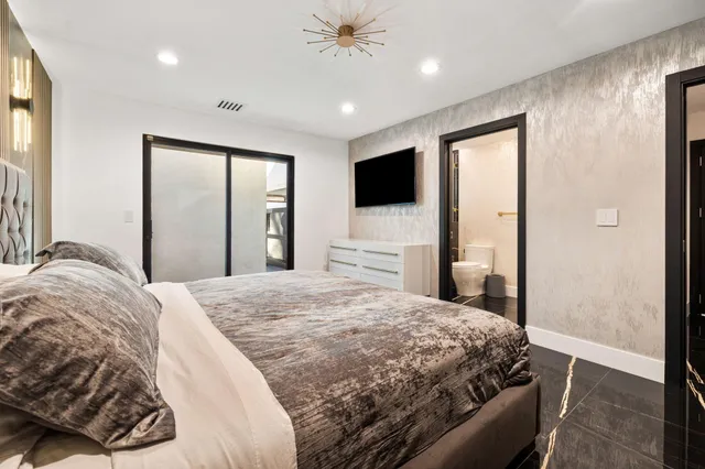 a bedroom with a bed and a refrigerator