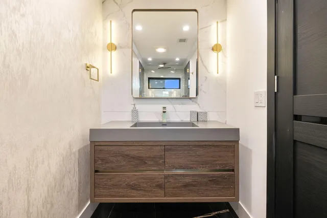 a bathroom with a sink a mirror a toilet and a shower curtain