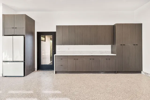 a spacious bedroom with a bed and a painting on the wall