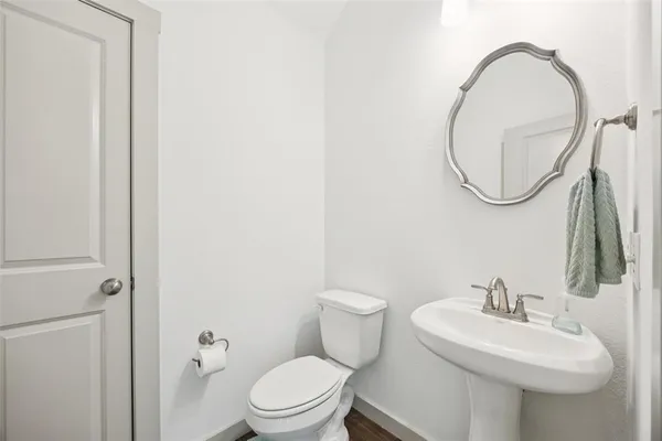a bathroom with a toilet a sink and a mirror