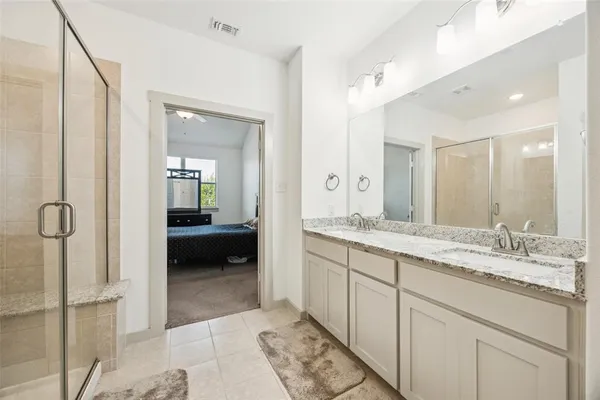 a en suite bathroom with a granite countertop sink and a mirror