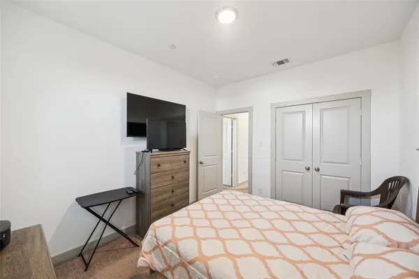 a bedroom with a bed and a flat screen tv