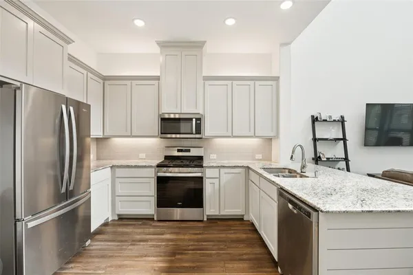 a kitchen with stainless steel appliances granite countertop a refrigerator stove and sink