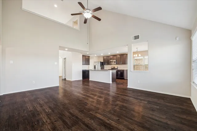 a view of empty room with wooden floor and window