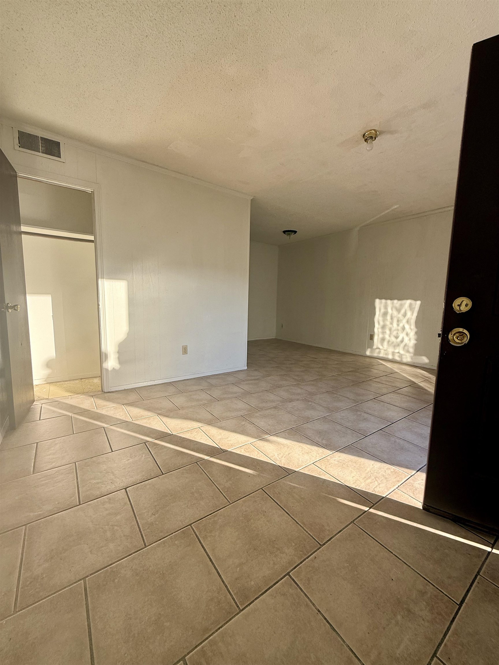 3091 Range Line Road Memphis, TN 38127 - Photo 3 of 13 Empty room with a textured ceiling and light tile patterned floors