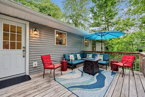 an outdoor sitting area with furniture and umbrella