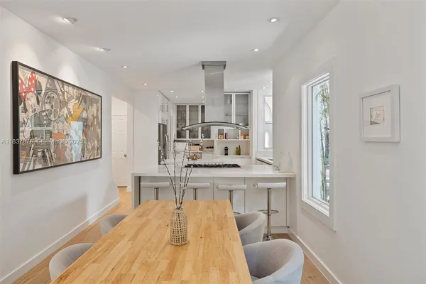 a kitchen with stainless steel appliances granite countertop a refrigerator a stove and white cabinets with wooden floor