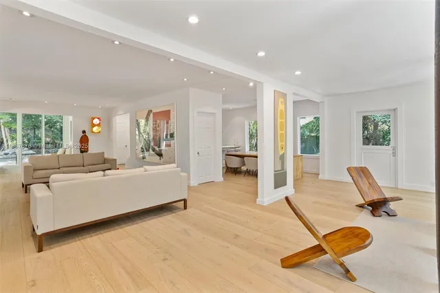 a living room with furniture pool table and glass door