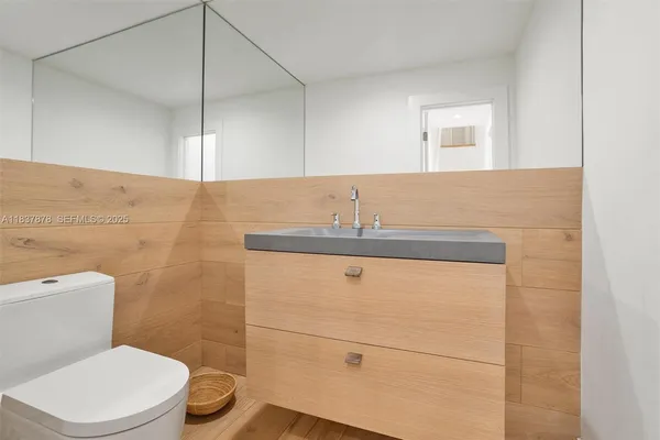 a bathroom with a sink a toilet and mirror