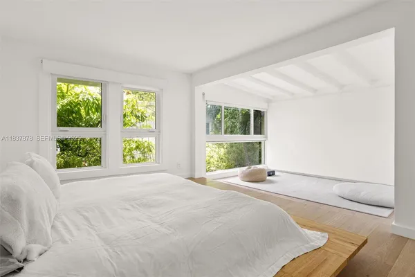 a large bed sitting in a bedroom next to a window