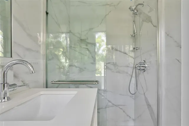 a bathroom with a granite countertop shower a sink and a mirror
