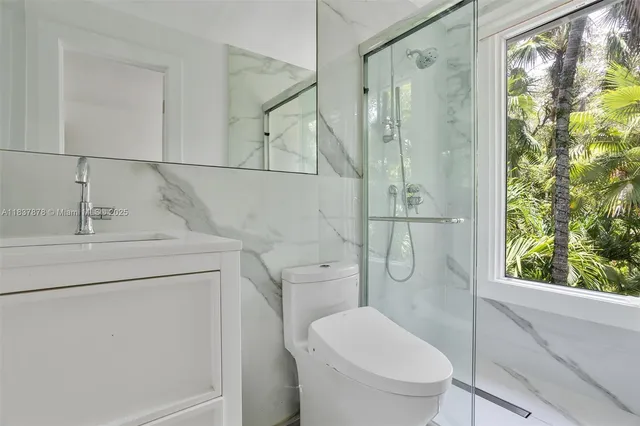 a bathroom with a granite countertop toilet sink and shower
