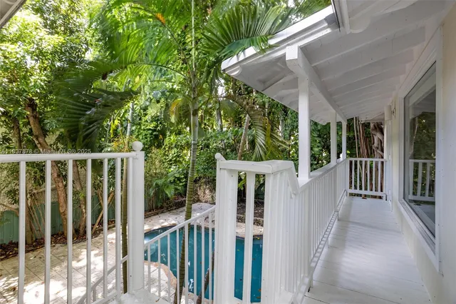 a view of a house with backyard and wooden fence
