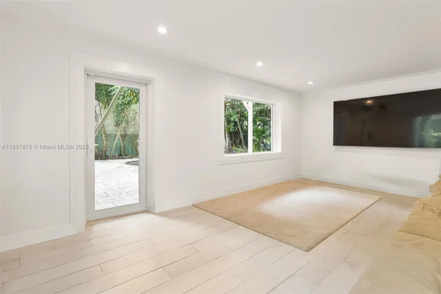 a view of an empty room with a window and a flat screen tv