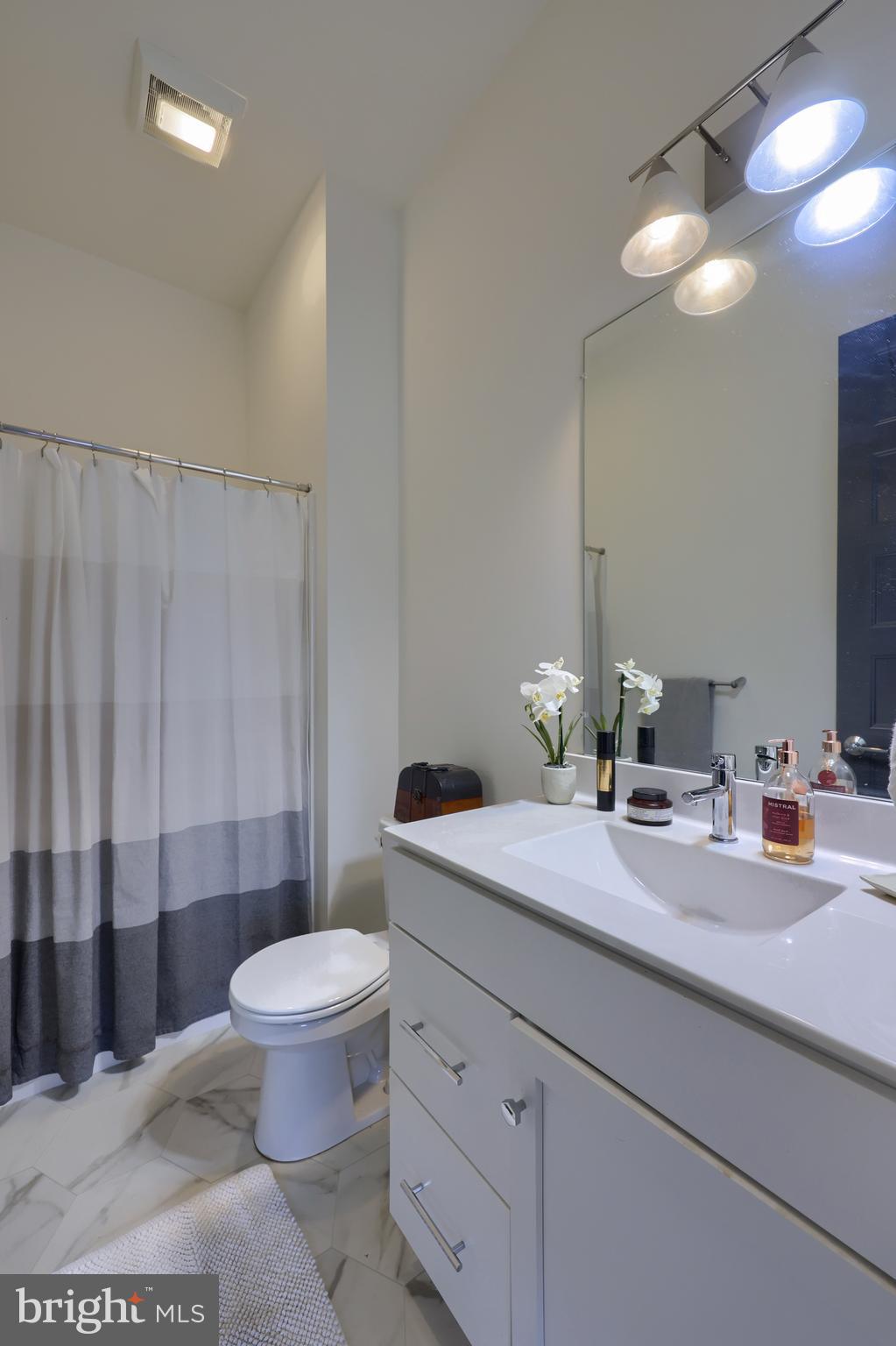 604 Stonehenge Drive Lititz, PA 17543 - Photo 8 of 41 a bathroom with a granite countertop sink a toilet a mirror and shower curtain