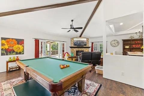 a bedroom with a bed couch and a large window with wooden floor