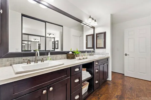 a spacious bathroom with a granite countertop sink a mirror a bathtub and shower