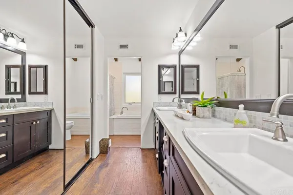 a bathroom with a sink double vanity granite tub and a mirror