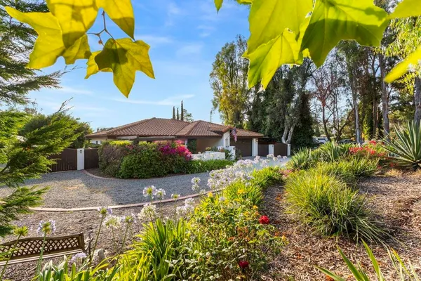 a view of a garden with a house in the background