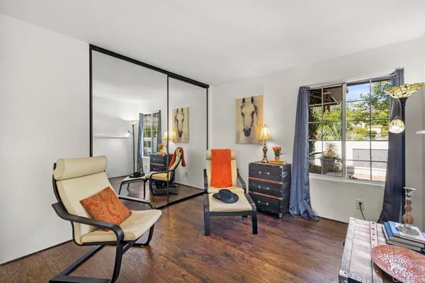 a balcony with wooden floor table and chairs