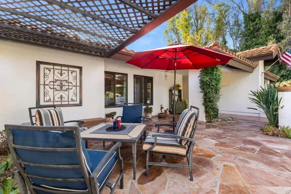 a view of a patio with a table and chairs under an umbrella