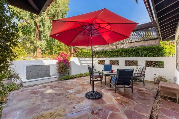 a patio with a table and chairs under an umbrella