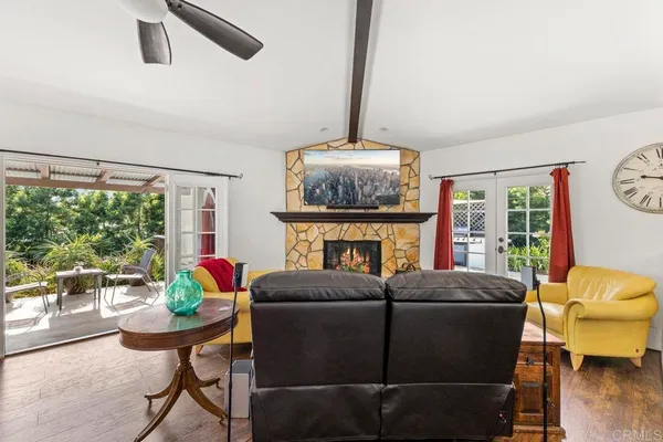 a living room with furniture a fireplace and a floor to ceiling window
