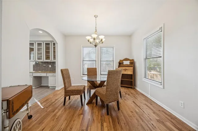 a dining room with furniture a chandelier and wooden floor