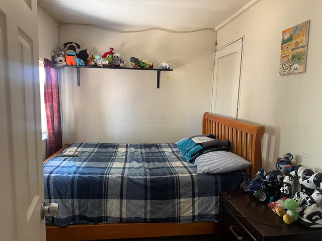 a bedroom with a bed a table and a chandelier