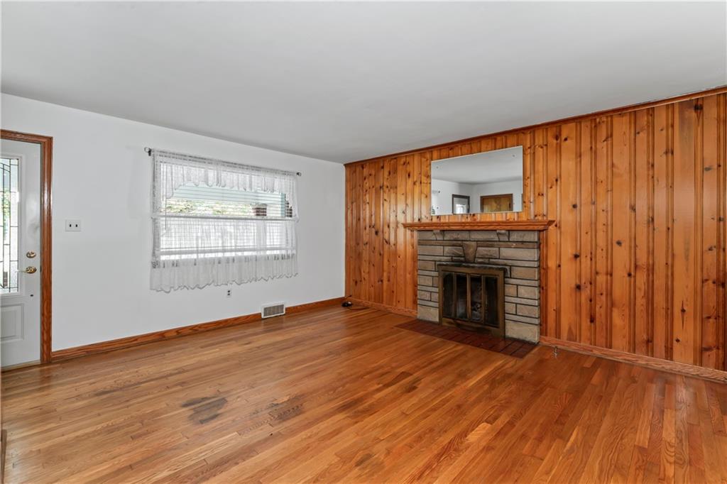 122 Georgetown Road Beaver Falls, PA 15010 - Photo 19 of 44 an empty room with windows a fireplace and wooden floor