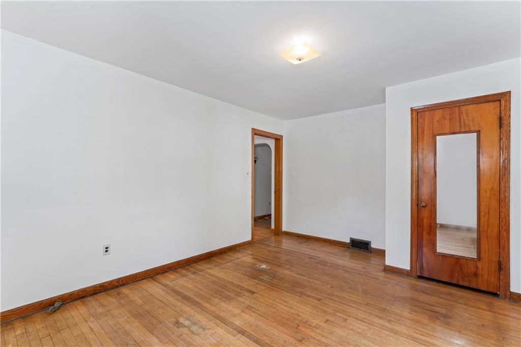 122 Georgetown Road Beaver Falls, PA 15010 - Photo 25 of 44 an empty room with wooden floor and mirror