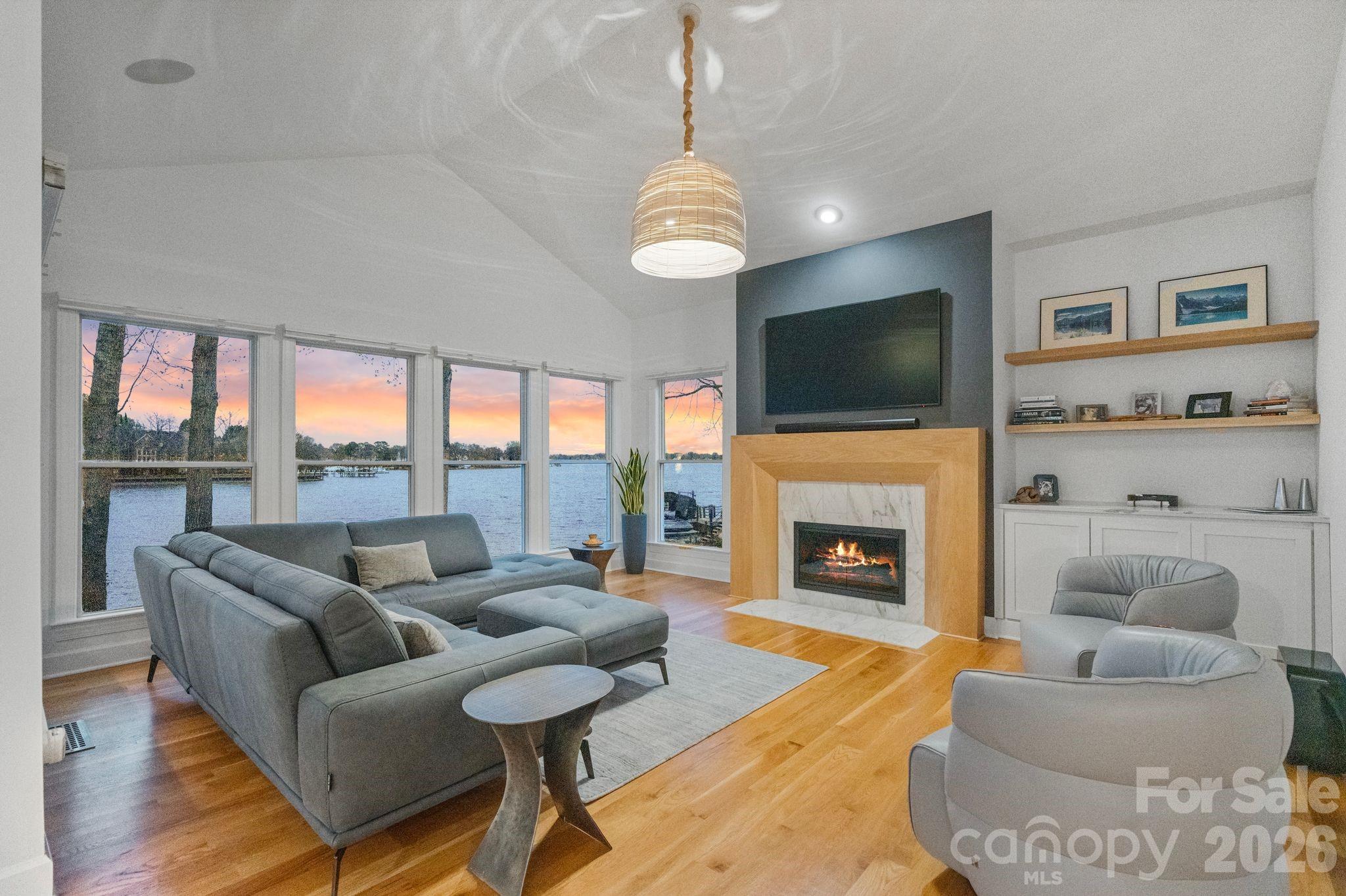 17723 Springwinds Drive Cornelius, NC 28031 - Photo 12 of 34 a living room with furniture a fireplace and a flat screen tv