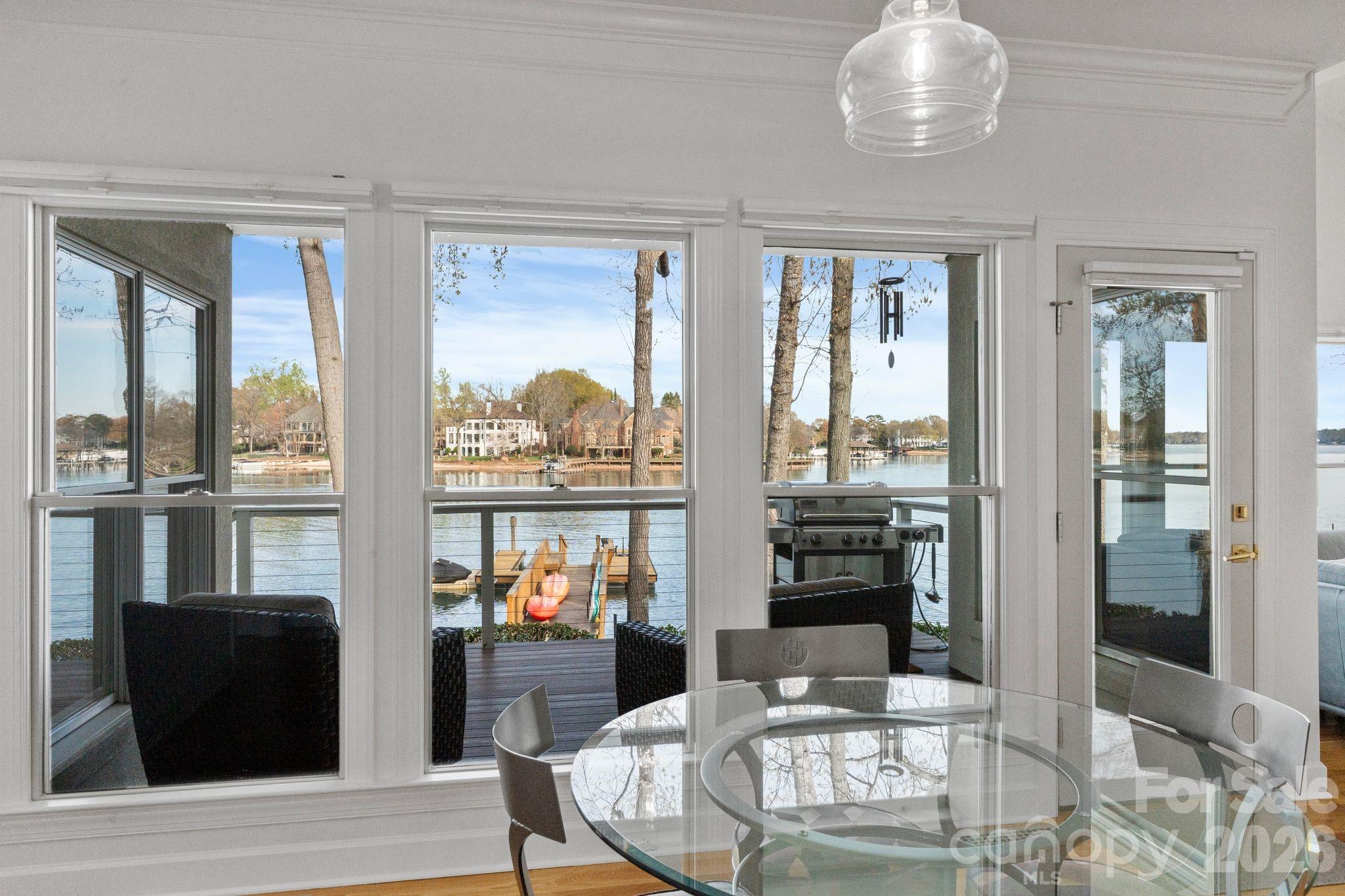 17723 Springwinds Drive Cornelius, NC 28031 - Photo 20 of 34 a dining room with wooden floor and a floor to ceiling window