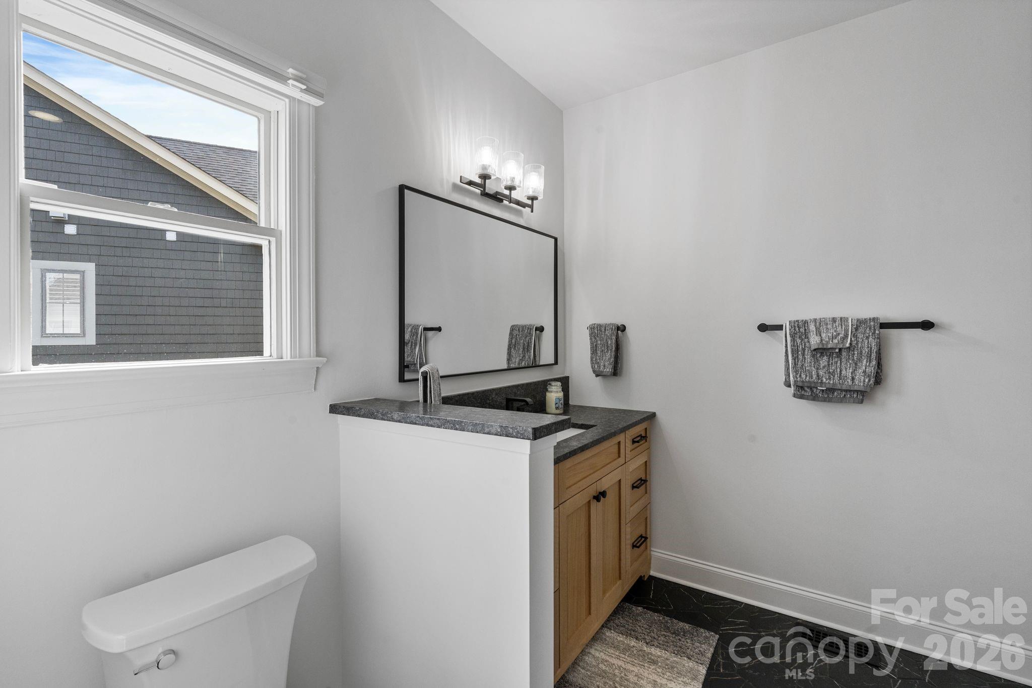 17723 Springwinds Drive Cornelius, NC 28031 - Photo 26 of 34 a bathroom with a granite countertop toilet sink and mirror