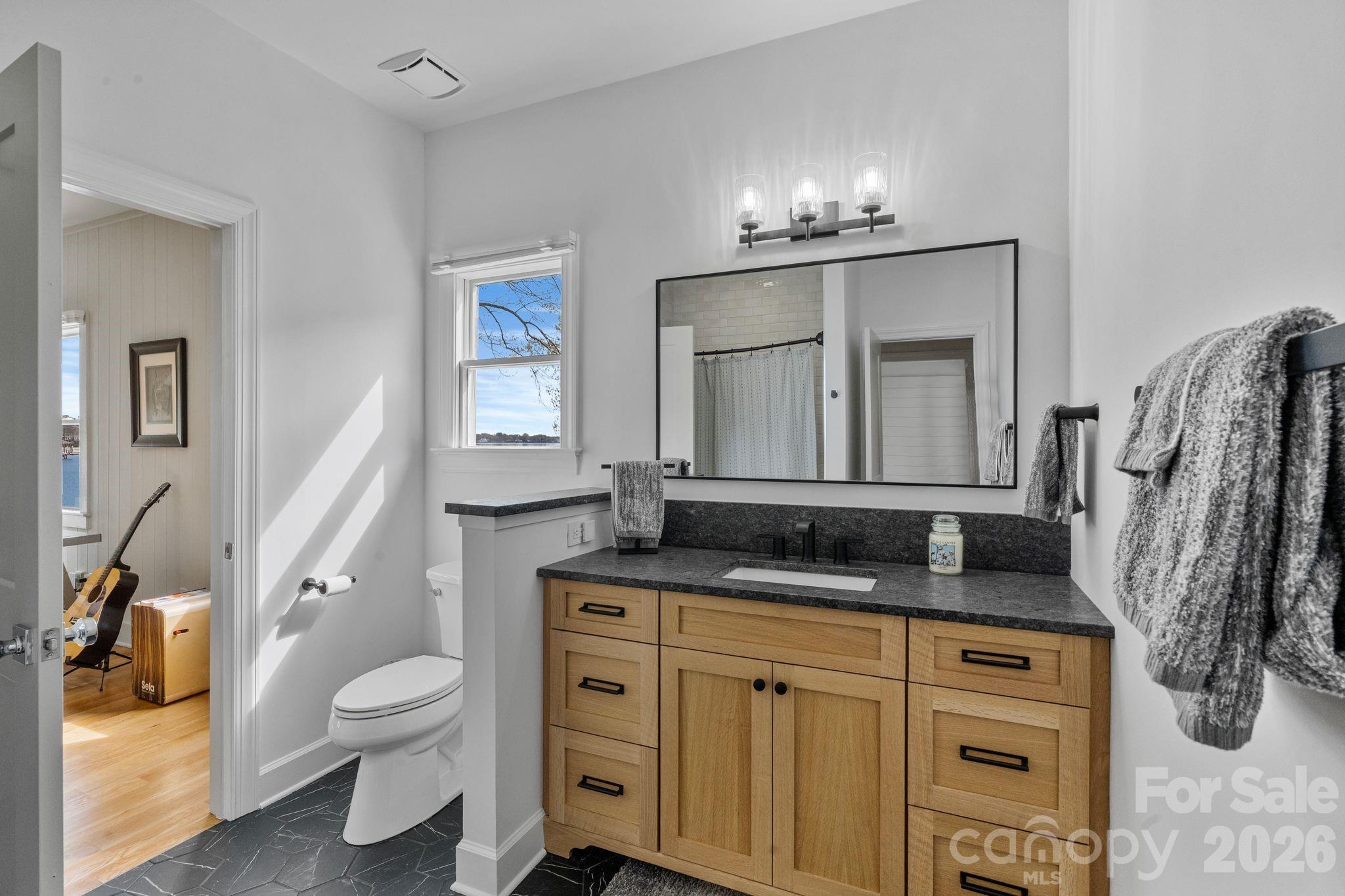 17723 Springwinds Drive Cornelius, NC 28031 - Photo 30 of 34 a bathroom with a granite countertop sink toilet and mirror