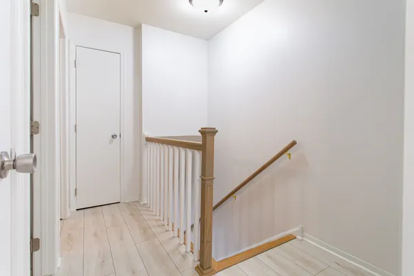 a view of a hallway with wooden floor and staircase